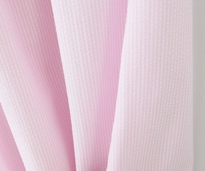 Detailansicht der atmungsaktiven rosa-weiß gestreiften Seersucker-Stoffstruktur am Kleid