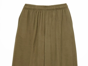 Detail of olive green trousers featuring elastic waistband and decorative front seam