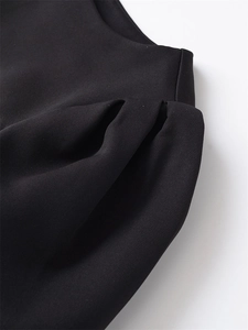 Detailed close-up of ruched black fabric with elegant pleated texture and soft drape