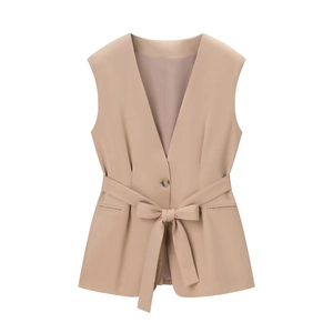 Detail view of the elegant beige vest featuring a deep V-neck and a tied bow waist belt