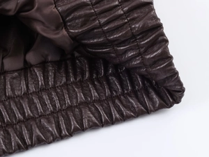 Vue macro détaillée de la veste en cuir PU marron foncé avec ourlet élastique et doublure