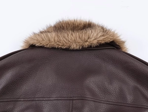 Détail de la veste en cuir marron foncé montrant la texture et le col en fourrure synthétique
