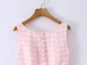 Detail of pink gingham sleeveless top with decorative back buttons on a wooden hanger