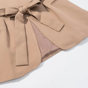 Close-up of khaki sleeveless vest waist tie and premium woven fabric texture detail