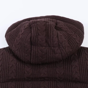 Detail of deep brown cable-knit texture and hood design on women's winter jacket
