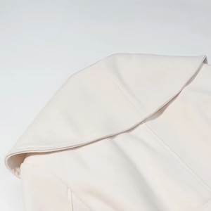 Detailed close-up of wide lapel design on off-white wool blend winter coat for women