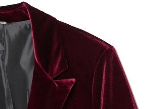 Dettaglio del risvolto del blazer in velluto bordeaux che mostra la trama lucida del tessuto