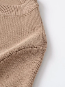 Close-up of ribbed crewneck and smooth shoulder seams on camel knit sweater