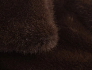 Gros plan détaillé sur la texture de fausse fourrure marron foncé et les fibres
