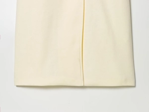 Detail of slim wool blend coat featuring precise stitching and a side slit design