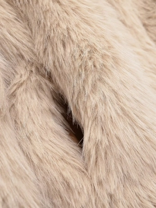 Detailed macro shot of soft apricot faux fur texture on a luxury winter jacket