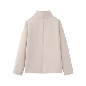 Dettaglio del retro del cappotto di lana beige con cuciture verticali e spalle scese