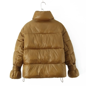 Detail of caramel glossy puffer jacket showing stand collar and elastic sleeve cuffs