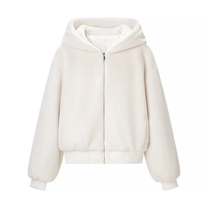 Détail de la texture en fausse fourrure blanche d'une veste à capuche avec zip