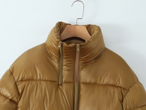 Close-up of caramel winter puffer jacket with high collar and double zipper details
