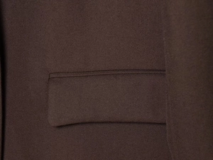 Vue macro du tissu en sergé marron et détails de couture sur le rabat de poche