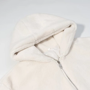 Détail de la capuche en fausse fourrure moelleuse et du zip argenté sur le manteau d'hiver