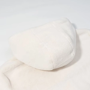 Vue détaillée de la texture douce en fausse fourrure blanche sur la capuche de la veste
