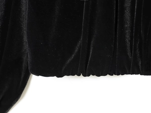 Dettaglio macro del tessuto in velluto nero con texture a pieghe e finitura lucida morbida
