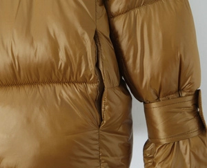 Close-up of brown glossy puffer jacket with side pockets and metal cuff tie details