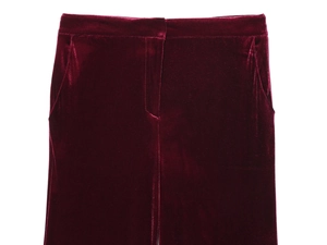Dettaglio macro dei pantaloni in velluto bordeaux a vita alta con tasche laterali