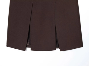 Détail de la jupe de tailleur plissée marron foncé avec doublure en satin lisse