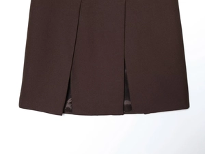Détail d'une jupe plissée marron foncé avec tissu tissé épais et doublure en satin chic