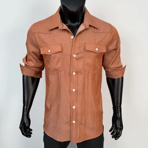 Detail of brick red long sleeve shirt featuring cargo pockets and contrast white buttons