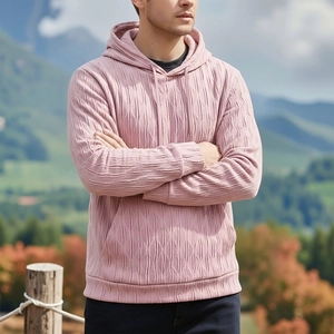 Gros plan d'un sweat à capuche rose pour homme avec tissu texturé gaufré et cordon de capuche