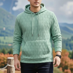 Détail d'un sweat à capuche vert clair avec tissu texturé 3D ondulé et poche kangourou
