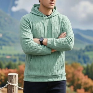 Détail d'un sweat à capuche vert clair avec tissu texturé 3D et capuche à cordon réglable