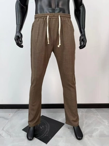 Dettaglio dei pantaloni marroni da uomo con texture traspirante e vita con coulisse