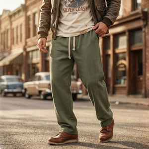 Dettaglio dei pantaloni in cotone verde militare con coulisse regolabile e tessuto in twill