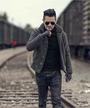 Men's dark grey winter coat with fleece collar and buttons in retro outdoor railway setting