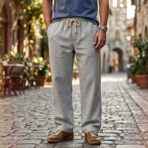 Dettaglio dei pantaloni grigi a spina di pesce con vita elastica a coulisse e tasche laterali