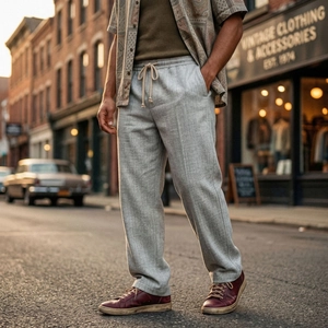 Dettaglio dei pantaloni grigi da uomo a spina di pesce con coulisse in un contesto vintage