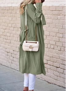 Detail of sage green midi trench coat featuring elegant bow cuffs and adjustable waist belt