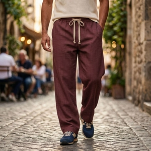 Dettaglio dei pantaloni in lino bordeaux con vita elastica a coulisse e taglio dritto