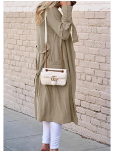 Detail view of the drawstring cuff and side pocket on this khaki mid-length trench coat