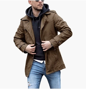 Trench casual marrone da uomo abbinato a felpa nera con cappuccio e jeans strappati