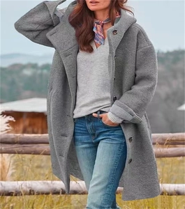 Scatto all'aperto di un cappotto lungo grigio con cappuccio, grandi bottoni e tessuto ruvido