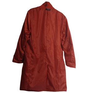 Detail view of the rear slit and back design on a long red double-breasted wool coat
