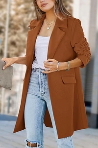 Street style detail of a long caramel brown wool coat with notched lapels and side flap pockets