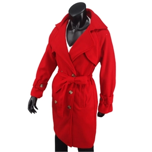 Détail d'un manteau en laine rouge avec boutons croisés, revers et ceinture nouée