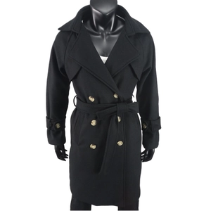 Détail d'un manteau en laine noir à double boutonnage avec revers et ceinture à nouer