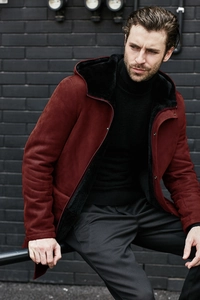 Close-up of men's burgundy suede parka featuring plush black faux fur lining and hood