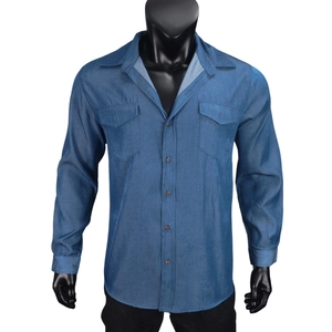 Detail view of denim texture men shirt showing chest pockets and wooden buttons