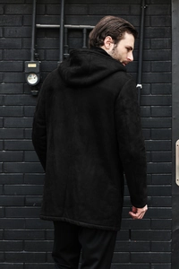Rear view of men's black hooded suede coat showing tailoring and winter texture
