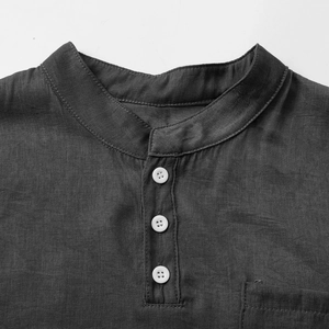 Detail of dark gray cotton linen Henley shirt neckline with white buttons and fabric texture