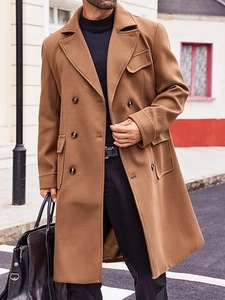 Detail of camel wool coat featuring double-breasted buttons and large flap pockets
